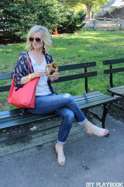 Bridget enjoys a soft pretzel on a bench in Central Park.