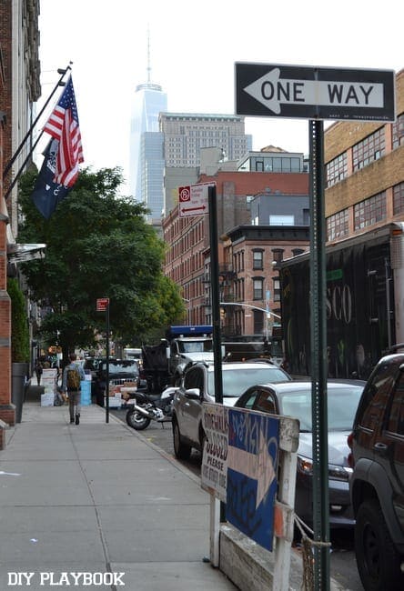 This NYC block features an American flag and street sign.