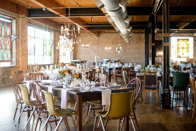 This reception room is beautifully decorates with colorful chairs and flowers.