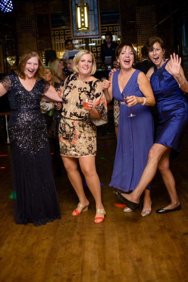 These wedding guests are dancing and having fun.