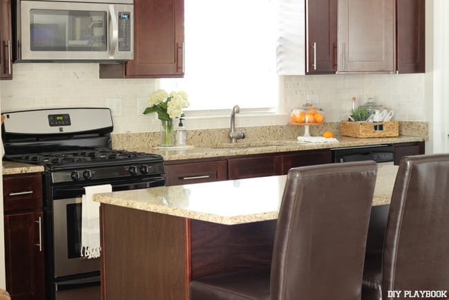 The white backslash in this kitchen pairs well with the tan granite counter tops.
