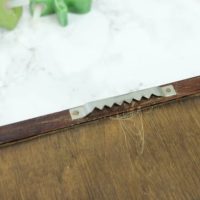 You want to remove the hanging metal strip off the back of your old shelf so it can sit flat. 