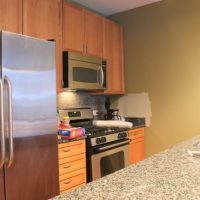 The appliances in this kitchen are stainless steel and new.