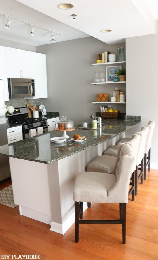 Maggie's feminine kitchen decor includes these beautiful bar chairs and white cabinets.