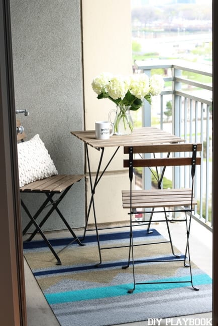 Maggie's balcony is effortlessly chic with this modern bistro table and gorgeous rug.