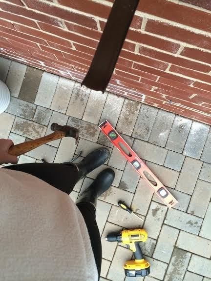 Using a hammer, secure the screws to the brick wall.