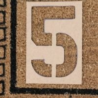 Place the stencil on the doormat