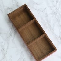 Divided wooden tray for office supplies like paper clips and push pins
