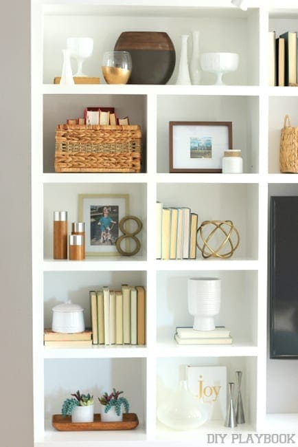 Built-in bookshelves decorated with thrifted home accessories.