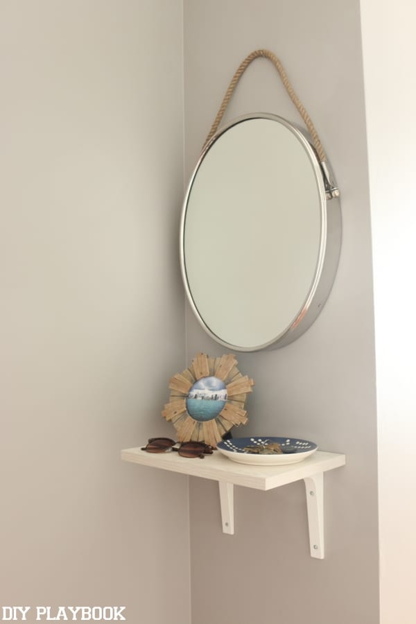 The addition of a simple round mirror and shelf really take the space up a notch!