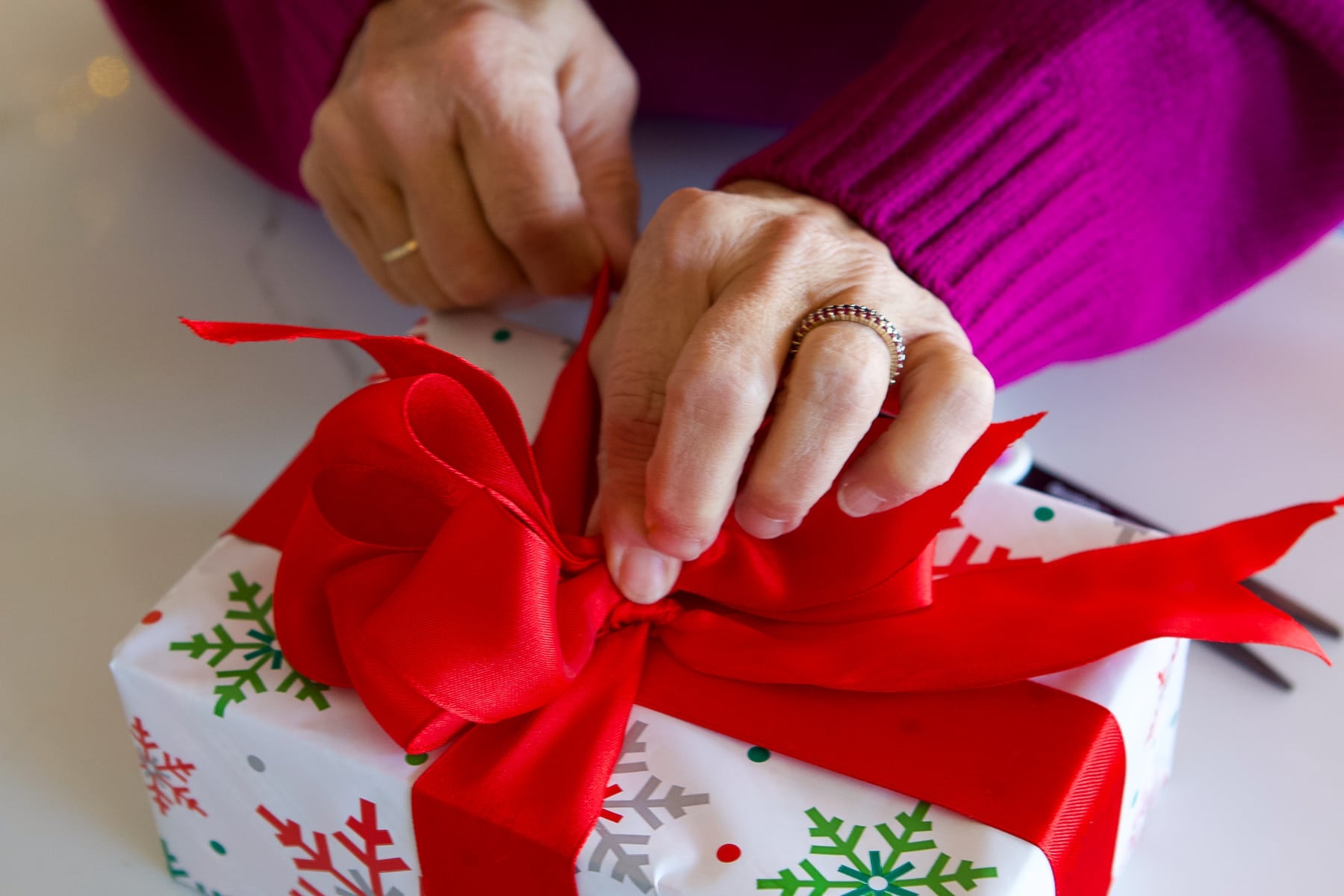 Tie the bow to the top of the present