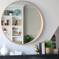 This circular mirror over the fireplace is a modern addition.