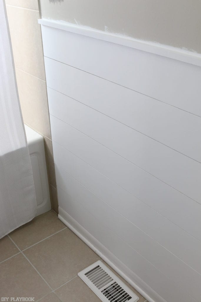 This white shiplap wall is a beautiful addition to any bathroom.
