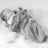 Babies are more comfortable being swaddled even in photos.