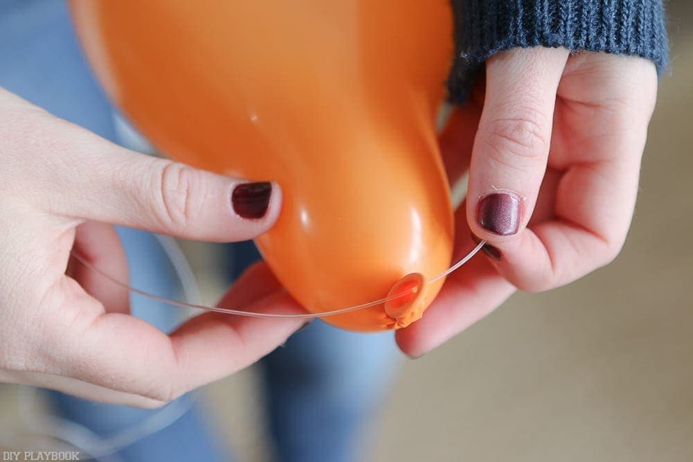 String fishing wire through the small hole you created with the safety pin