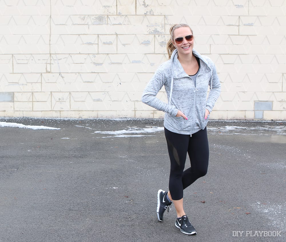 Some of Casey's favorite Athleisure Pieces to Wear Anytime include a grey zip up, black capri leggings and black tennis shoes. 