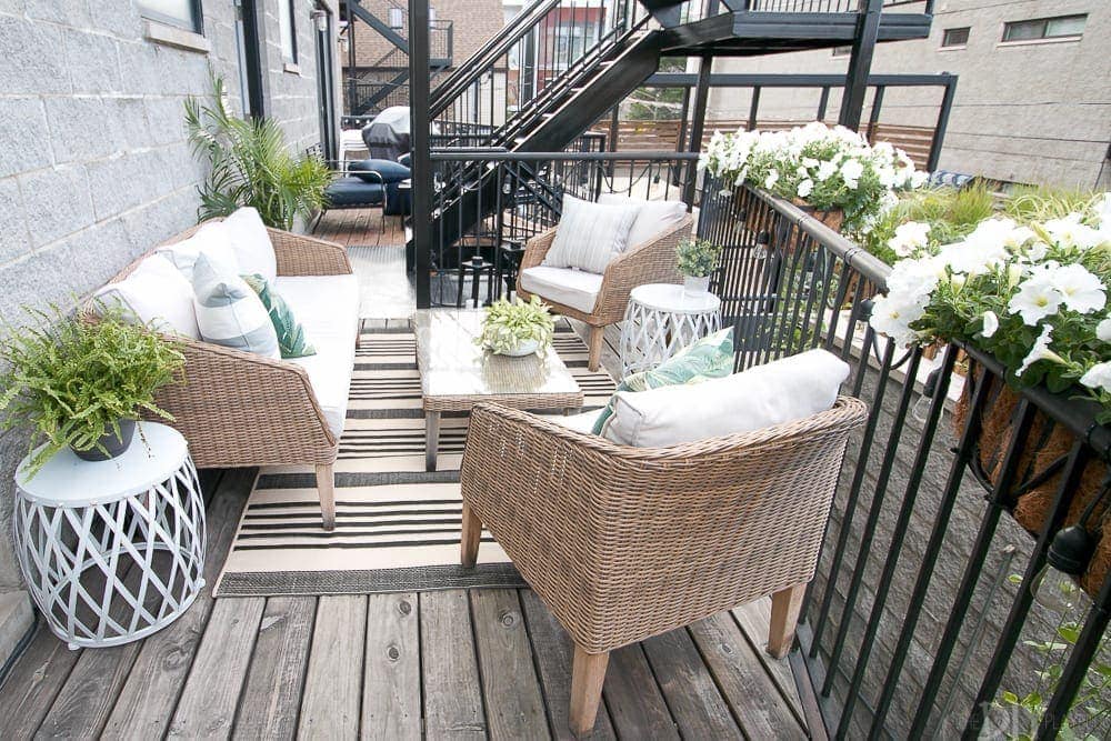 Our small outdoor patio got a major makeover with the addition of new wicker furniture, a rug and coffee table and lots of planters!