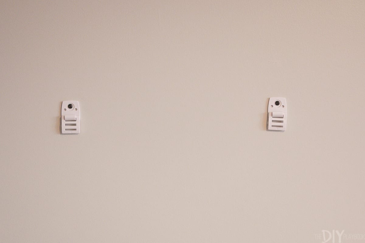 Putting furniture straps into the studs of your wall to babyproof your home.