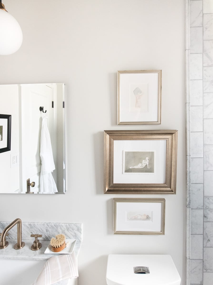 Hanging art over the toilet in a bathroom. 