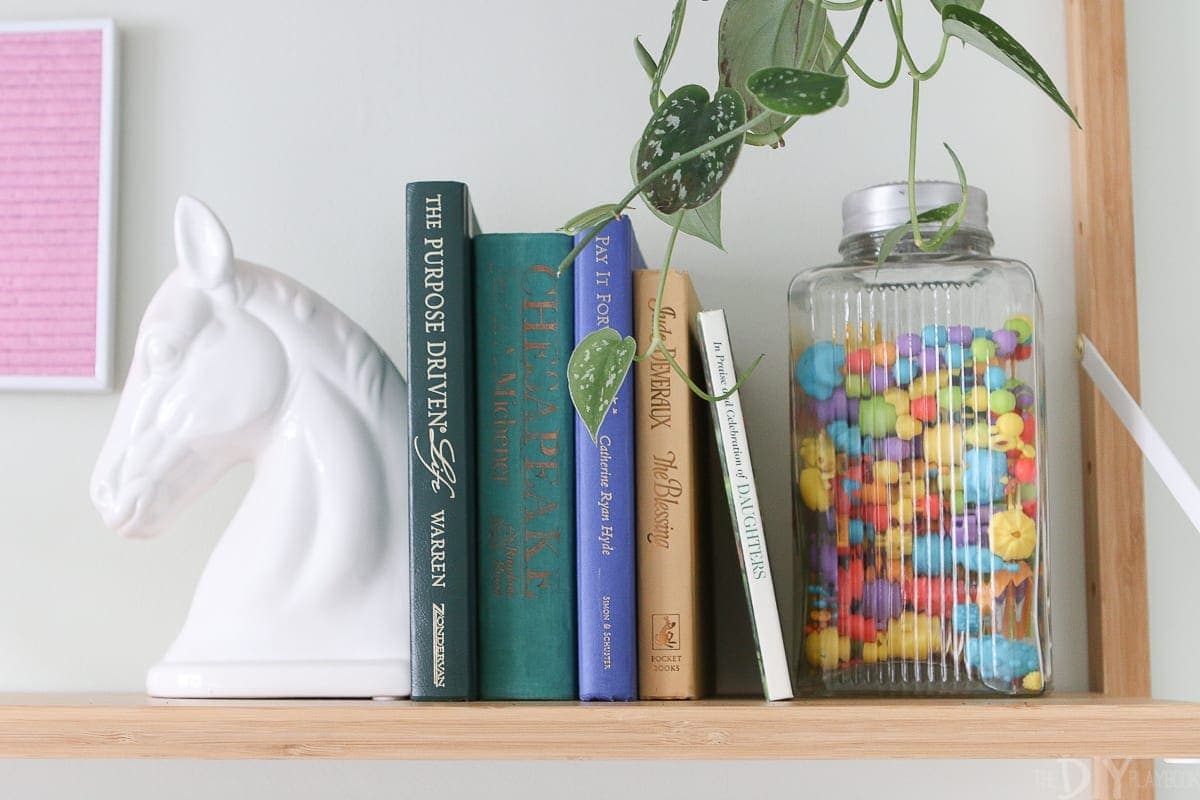Sandwich hardcover books between fun accessories in a kids' room. 