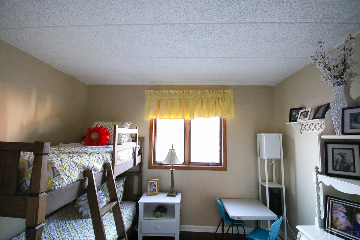 Yellow awning over a brown window in a kids' room. 