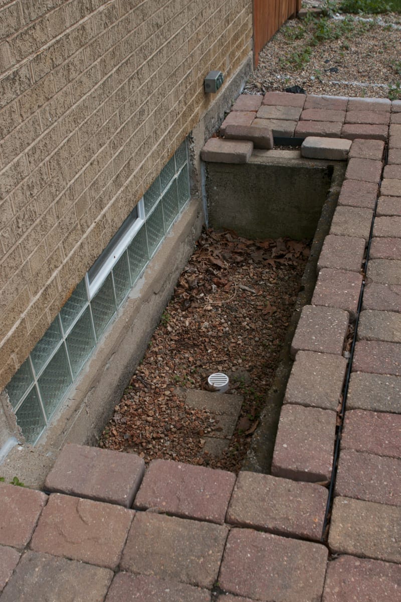 A window well that is a safety hazard outside on the patio