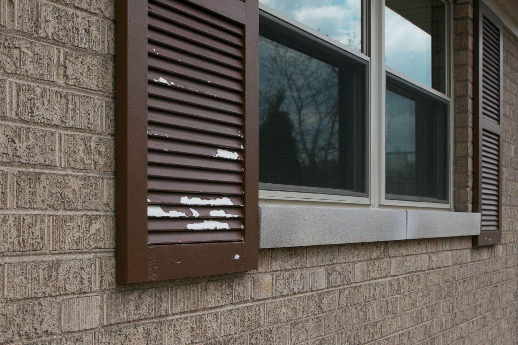 These brown shutters need to be painted to get rid of the peeling paint