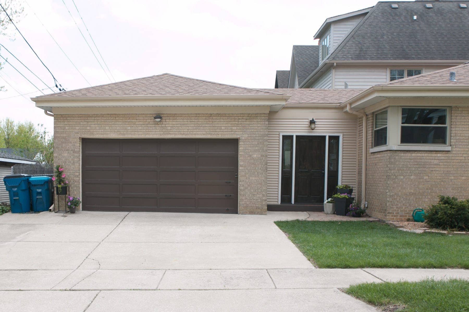 A brown garage door needs some attention to improve the curb appeal of this home. 