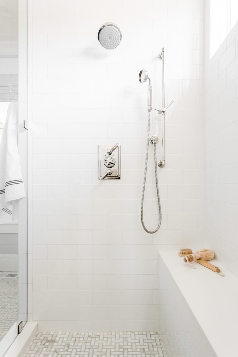 White shower tile and basketweave floor tiles