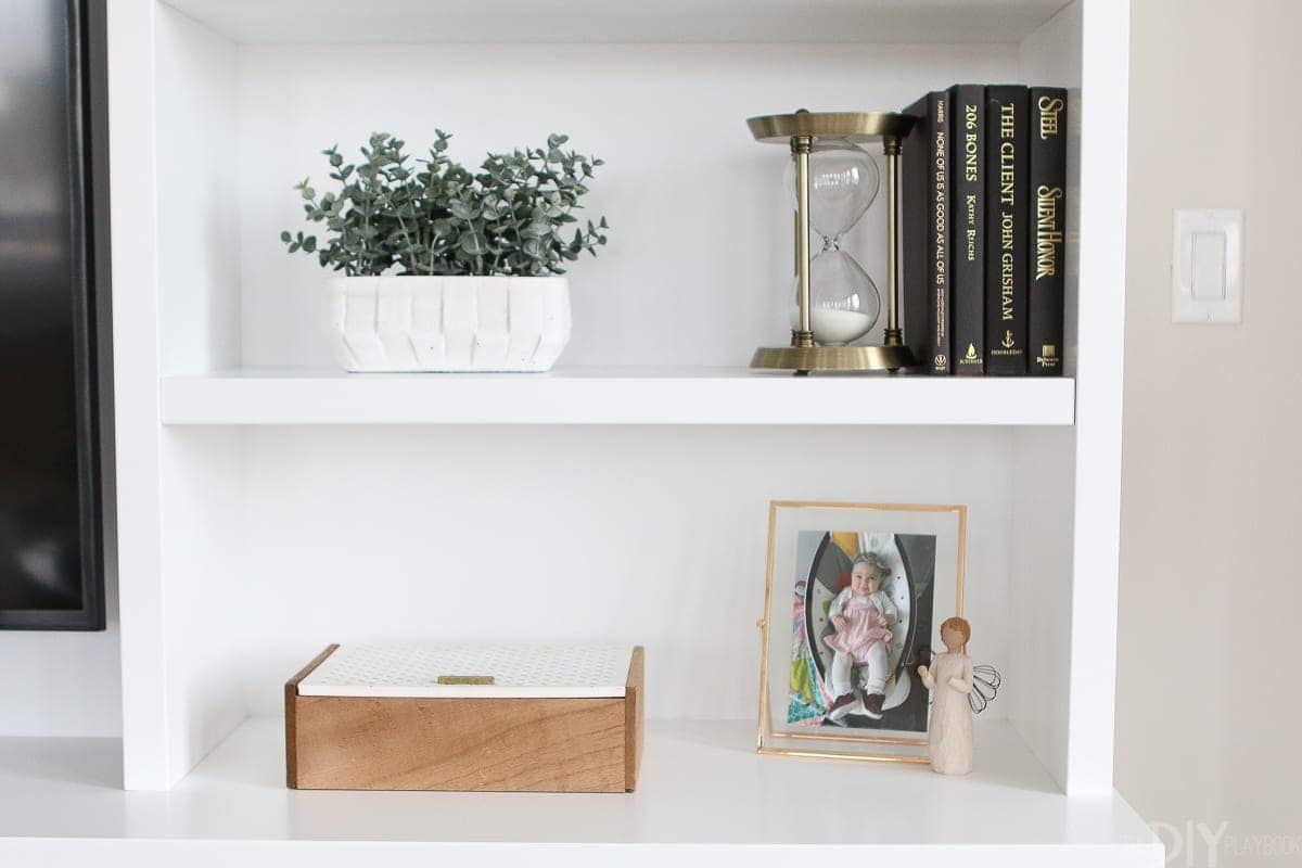 Layer in books, greenery, and picture frames to create the perfect shelfie. 