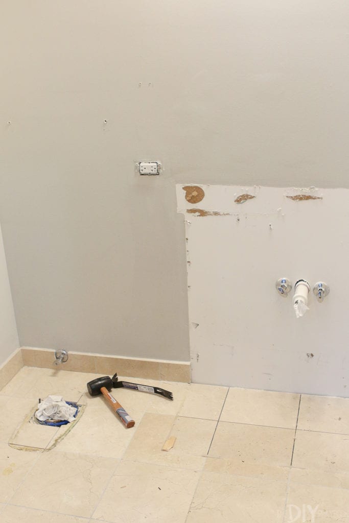 Use a chisel and mallet to remove floor tile