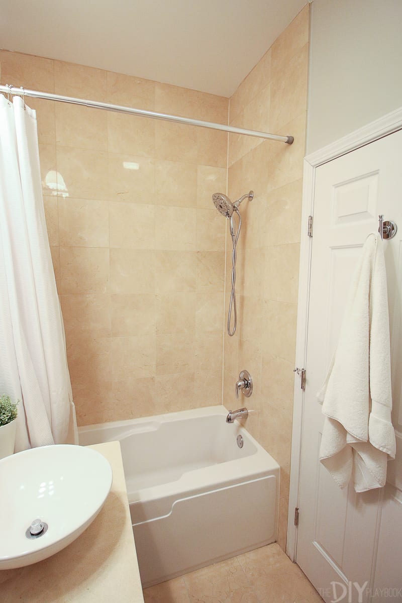 Bathroom shower area with tan tile walls