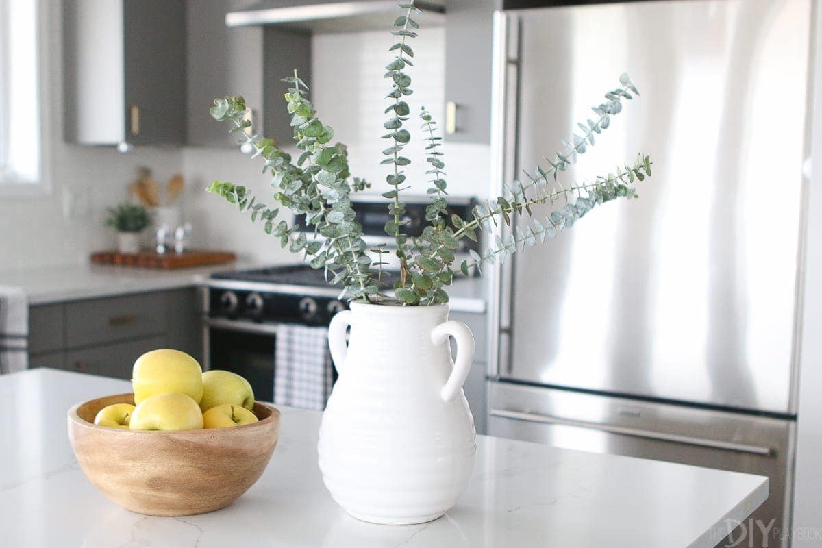Add eucalyptus to a white vase for kitchen decor. 