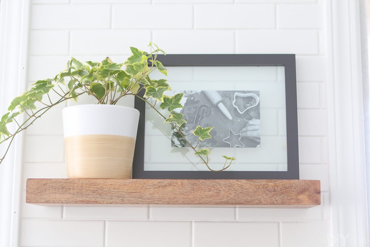 Use frames and plants to accessorize open shelving in the kitchen. 