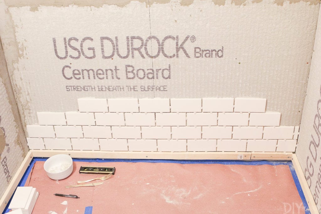 Use a ledger at the base of your wall to get a level line when installing subway tile in a shower