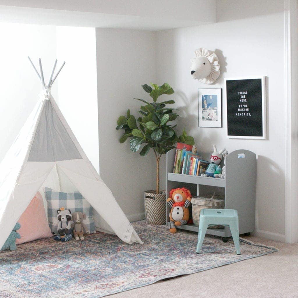 Using a teepee and bookshelves to create an organized playroom. 