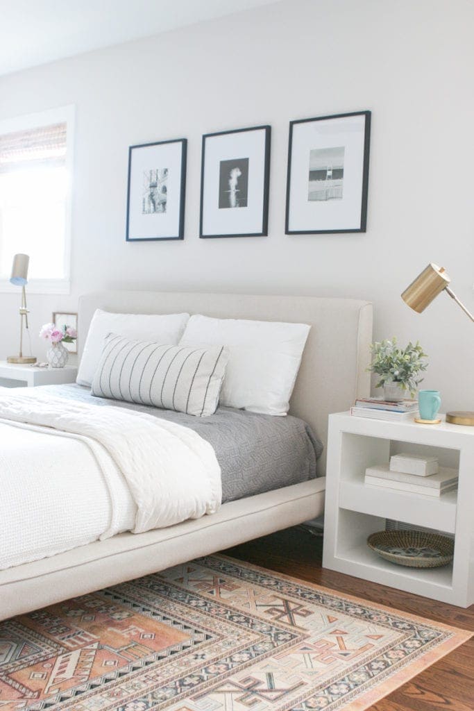 This neutral bedroom with a tribal rug and white nightstands is light and refreshing. 