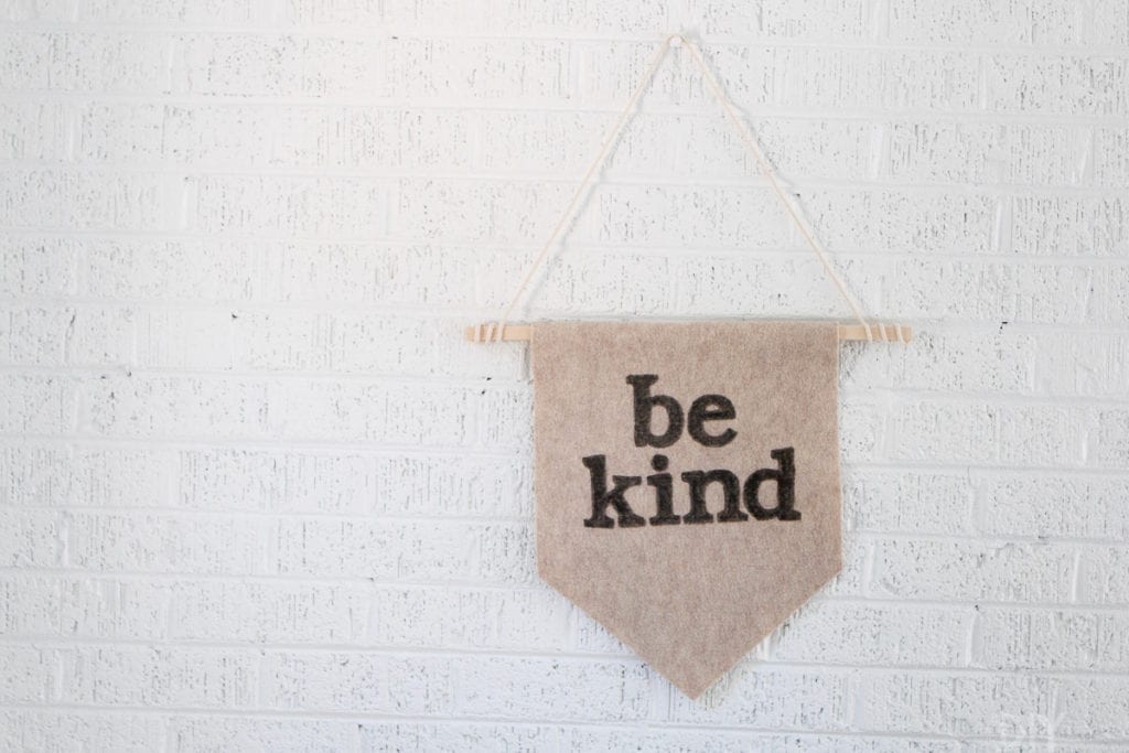 A wall pennant with the words Be Kind on it