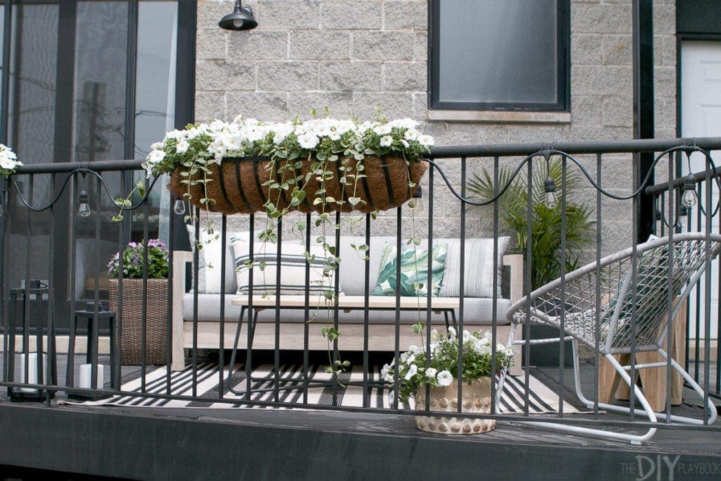 Add hanging flower boxes to a city balcony space