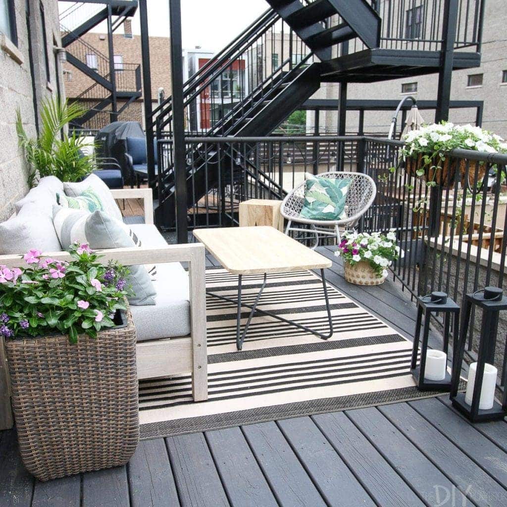 A small city patio with a couch and coffee table