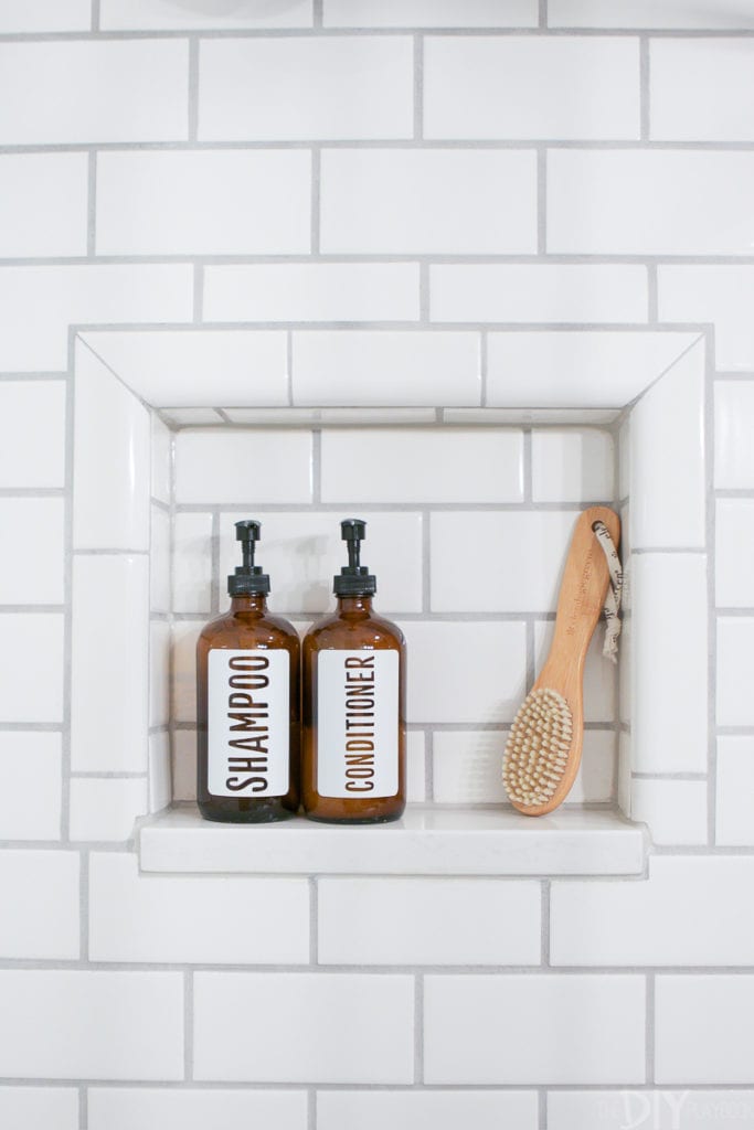 A subway tile shower niche with shampoo and conditioner bottles
