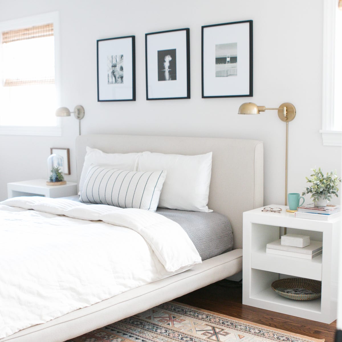 A neutral bed with white and gray bedding