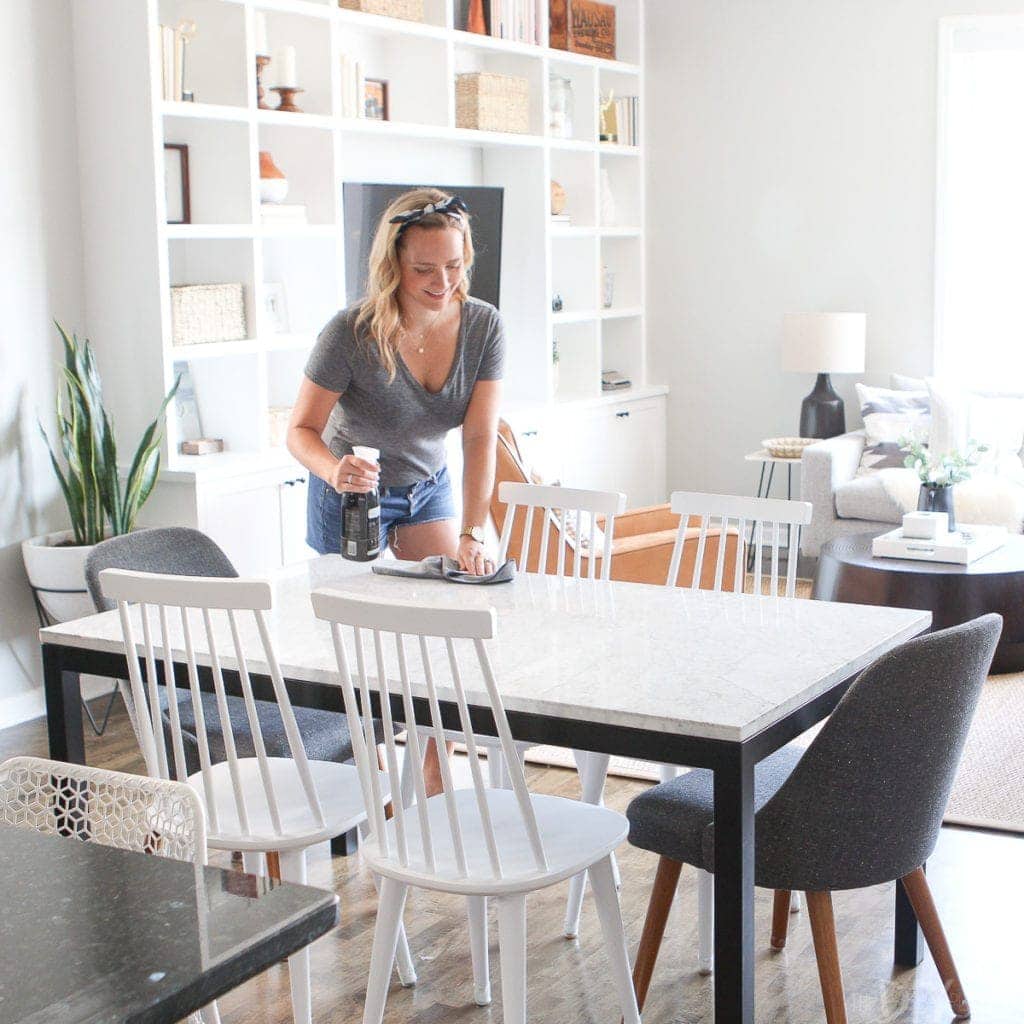 Wiping down dining table with microfiber cloth