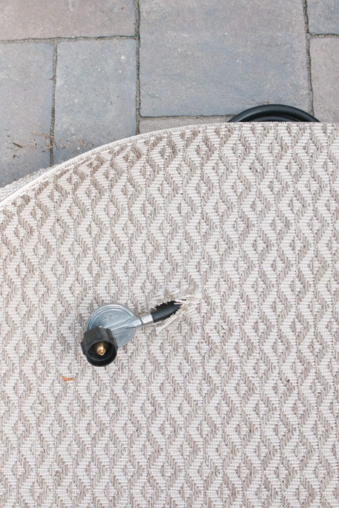 cutting an outdoor rug for a propane hose