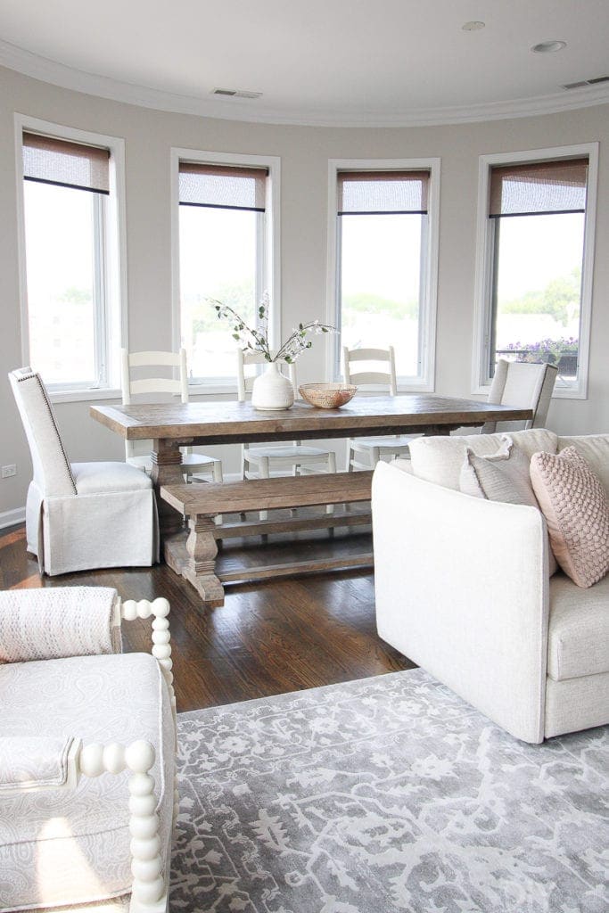 A farmhouse dining room with a bench and upholstered chairs. 