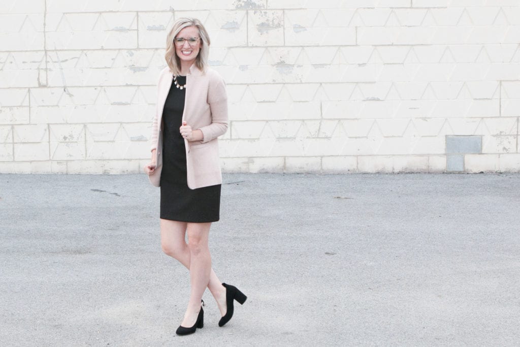 A black dress, necklace, and cream blazer