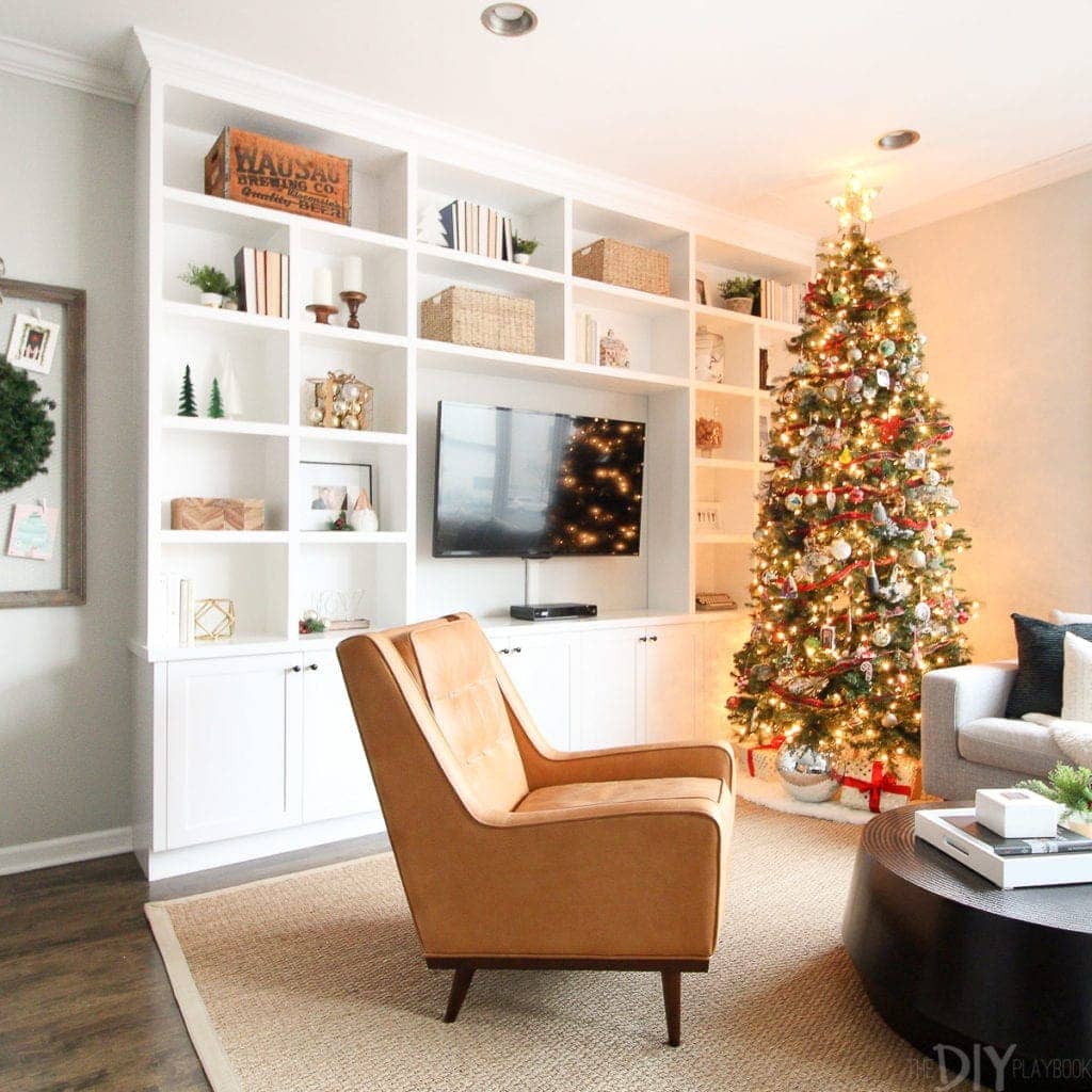 A Christmas tree near white built-ins
