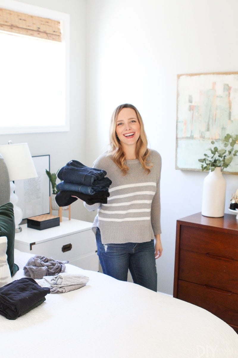 Casey holding jeans folded like Marie Kondo