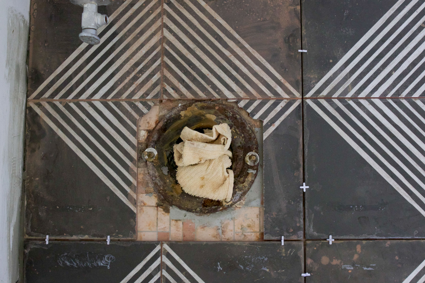 geometric tiles cut around the old tile