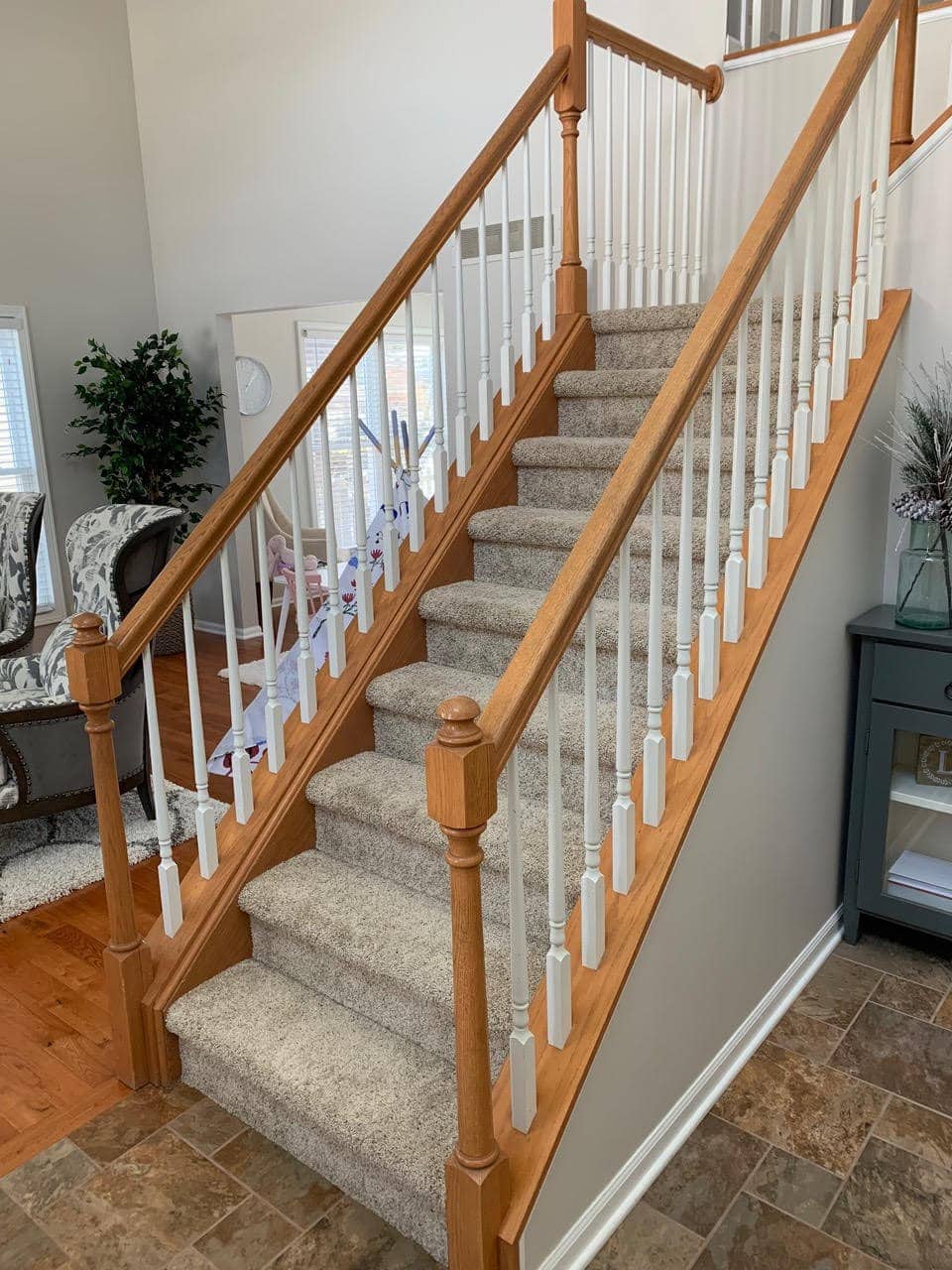 Carpeted stairs and white and wood spindles